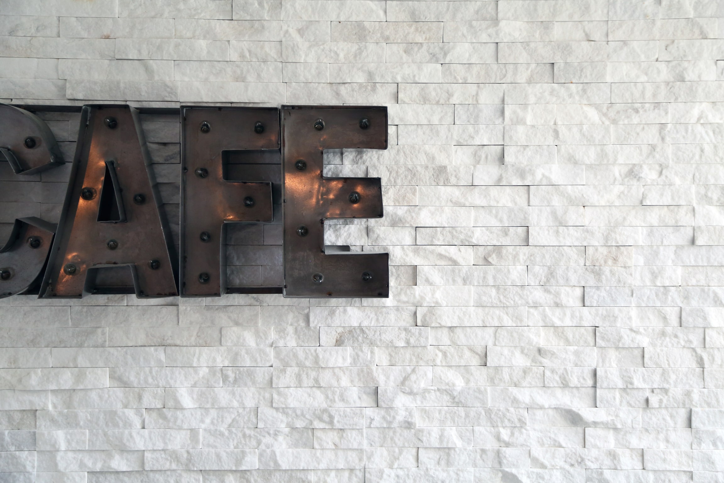 Norstone White Standard Series Rock Panels used in feature wall with a Cafe sign